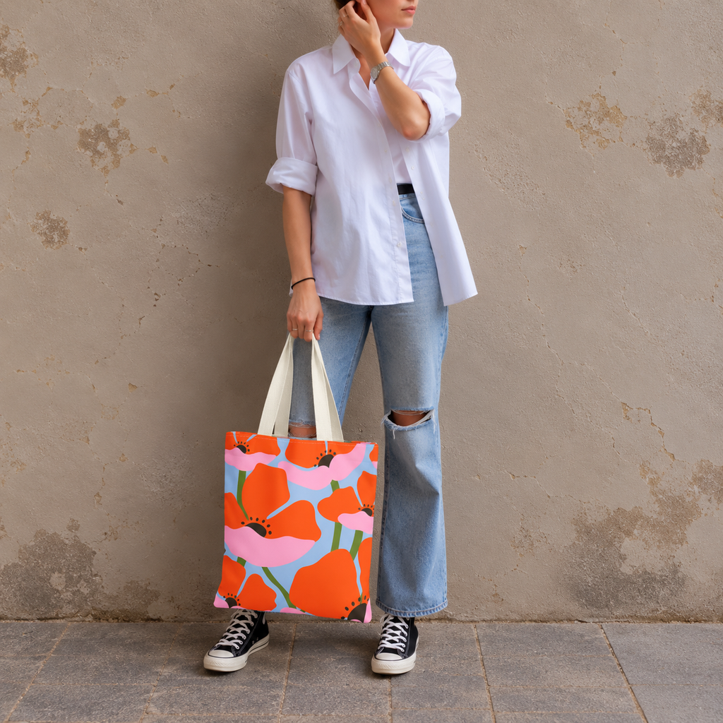 Woman in a white shirt and jeans standing with the orange poppy floral tote bag