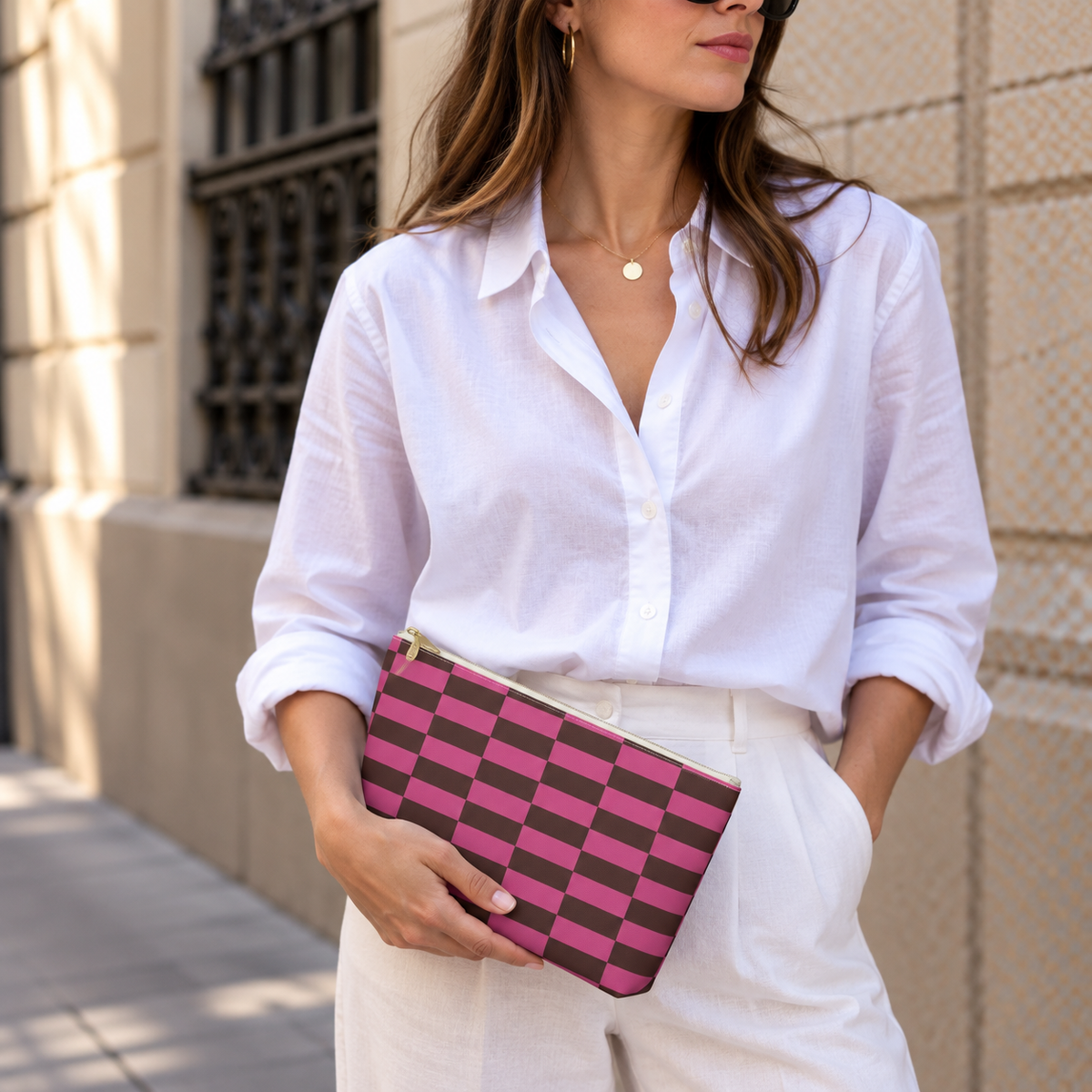 Woman in a white shirt holding the pink brown checkered makeup bag as a clutch
