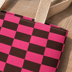 Close-up of the pink brown checkered print and handle on the tote bag