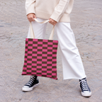 Woman in white trousers holding the pink brown checkered tote bag by the handles