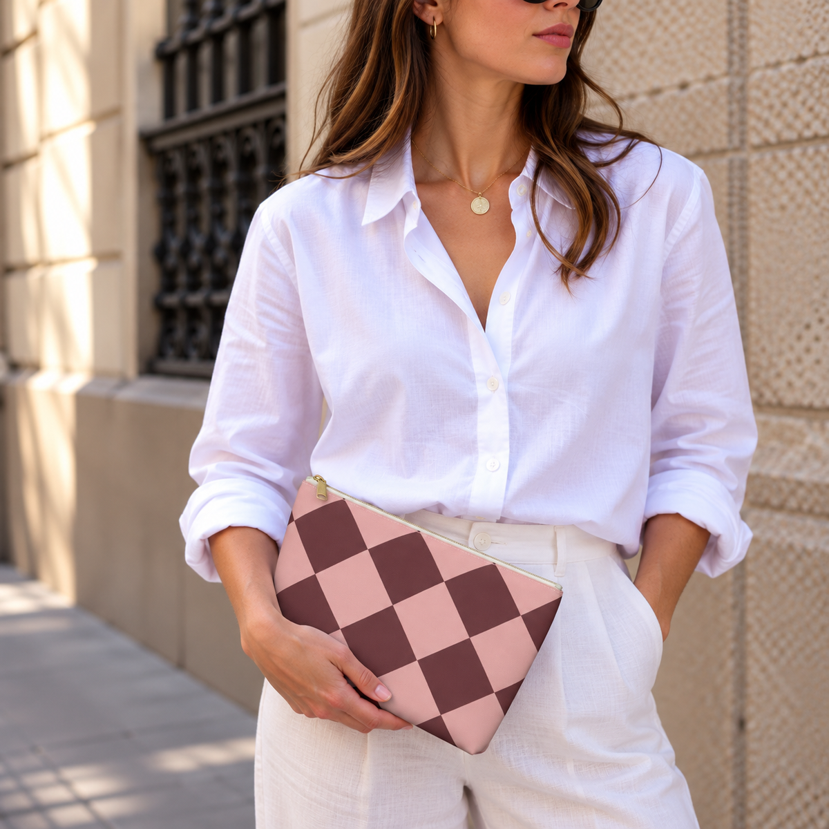 Woman holding the pink burgundy diamond checkered makeup bag