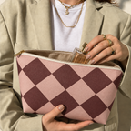 Open pink burgundy checkered makeup bag held in hands
