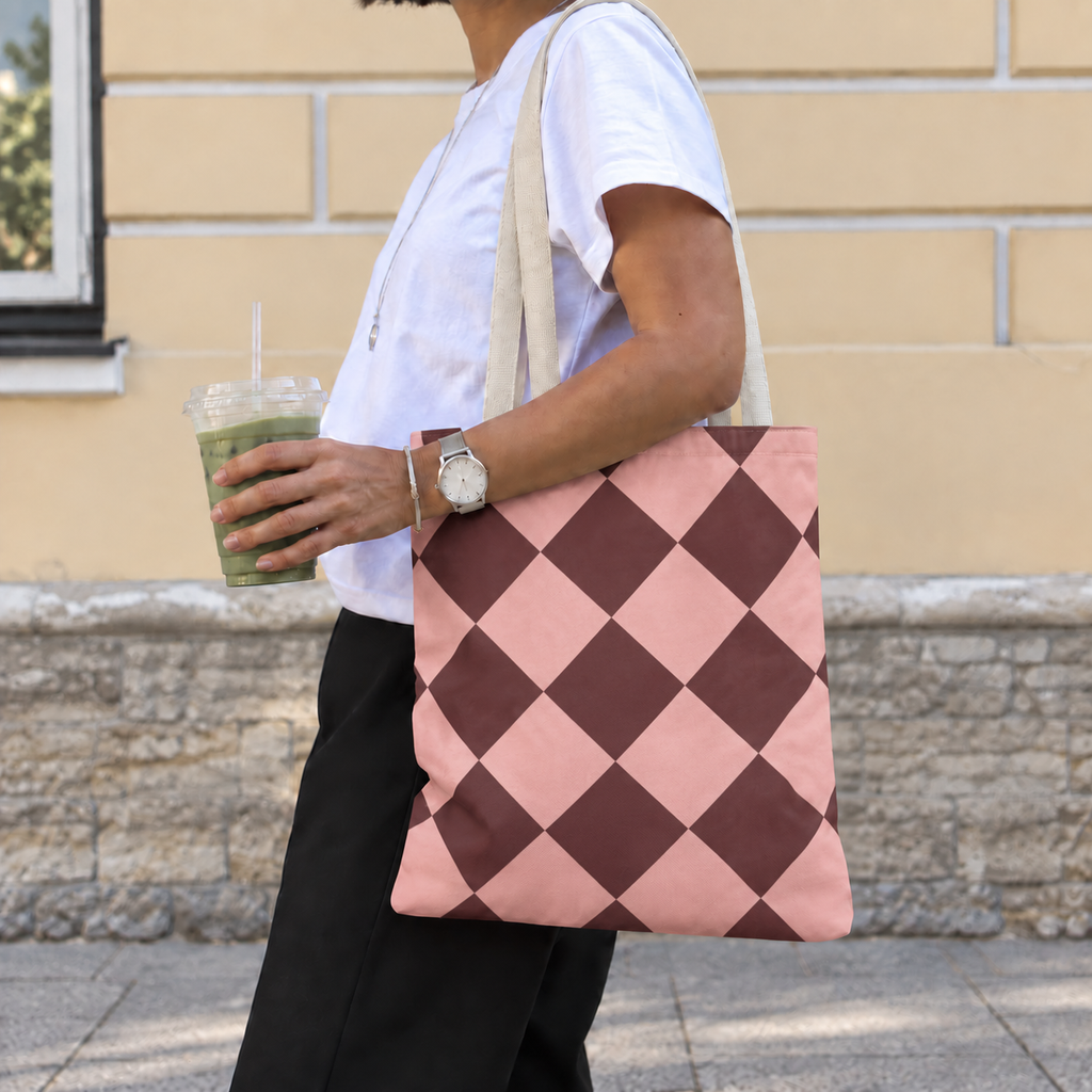 Pink burgundy diamond checkered tote bag worn on the shoulder with an iced drink