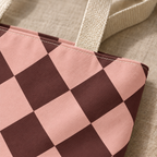 Close-up of pink and burgundy diamond checkered print on a tote bag