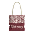 Pink burgundy zebra print personalized tote bag with a name on the burgundy panel, front view