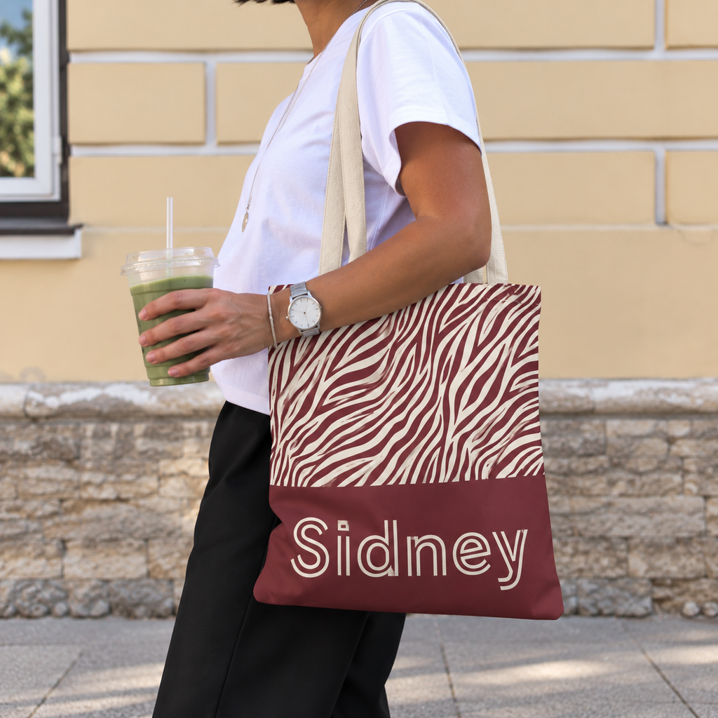 Personalized zebra print tote bag worn on the shoulder with an iced drink