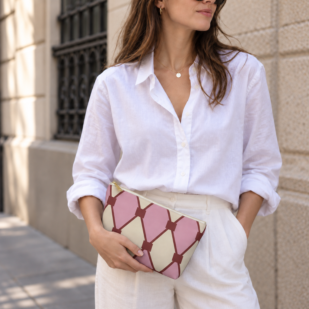 Woman in white shirt holding the pink cream diamond pattern makeup bag as a clutch
