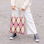 Woman in white trousers carrying the pink cream diamond pattern tote bag