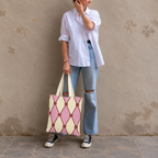 Woman in jeans and sneakers holding the pink cream diamond pattern tote bag