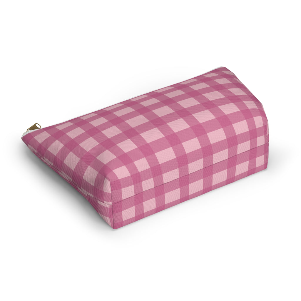 Pink gingham makeup bag lying at an angle on a white background