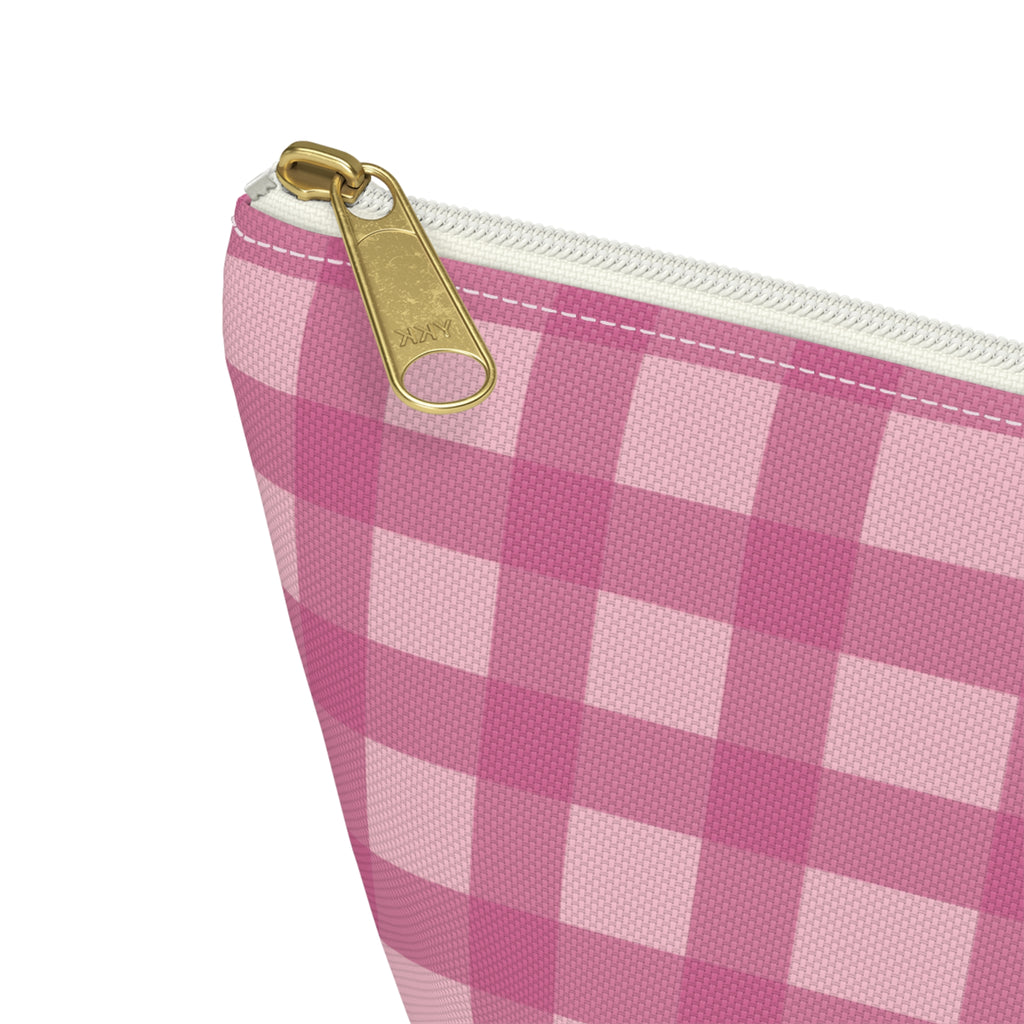 Close-up of the gold zipper pull on the pink gingham makeup bag