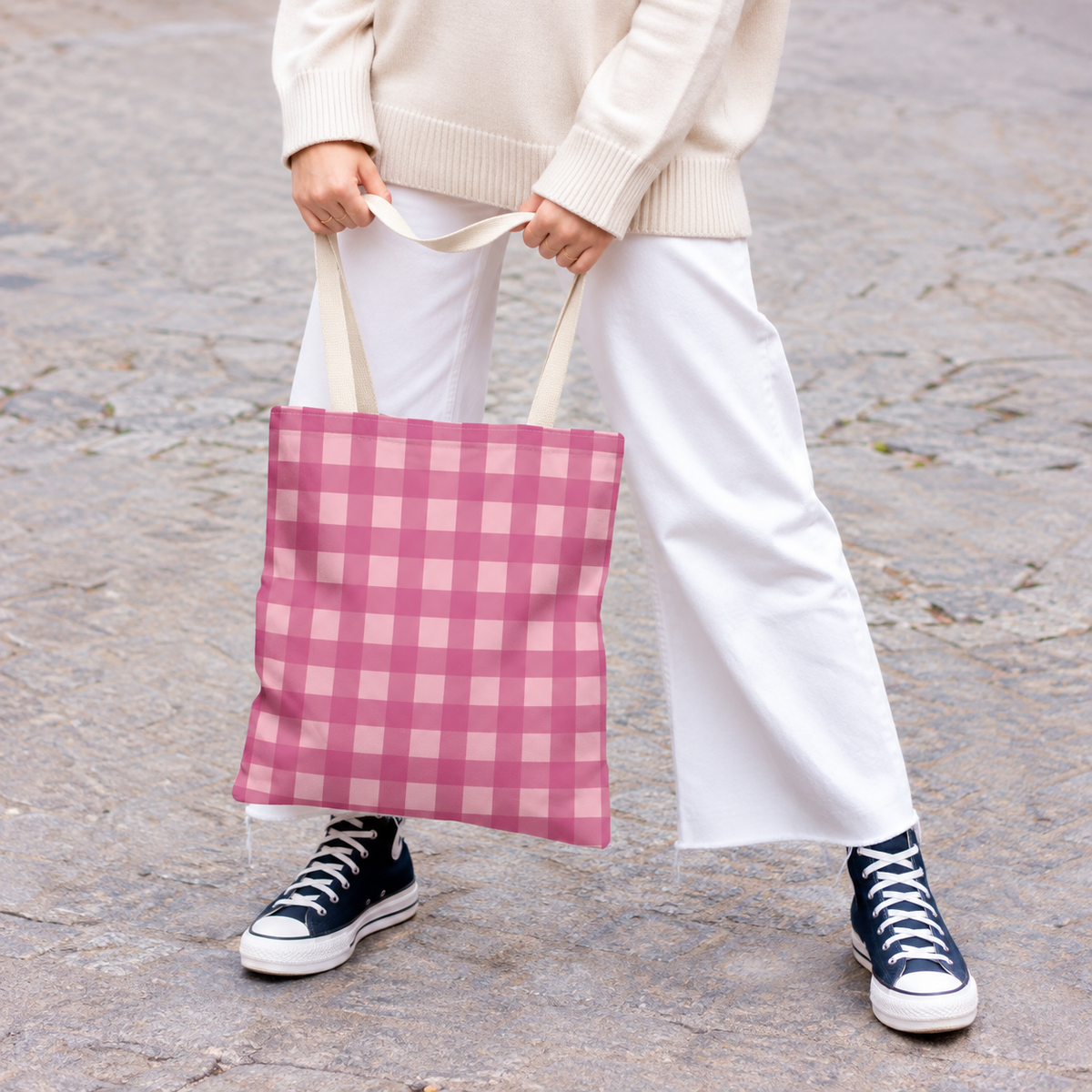 Model holding the pink gingham tote bag by its handles