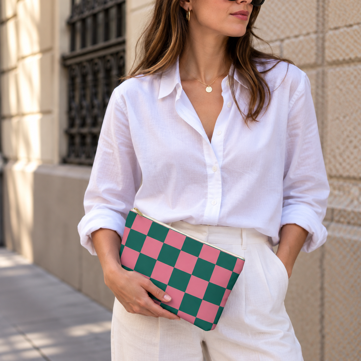 Model holding the pink green checkered makeup bag like a clutch