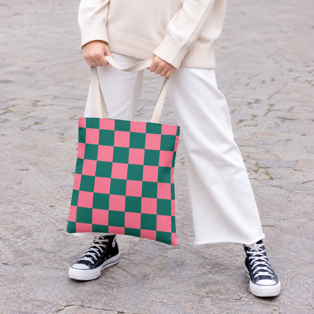 Model holding the pink green checkered tote bag by its handles