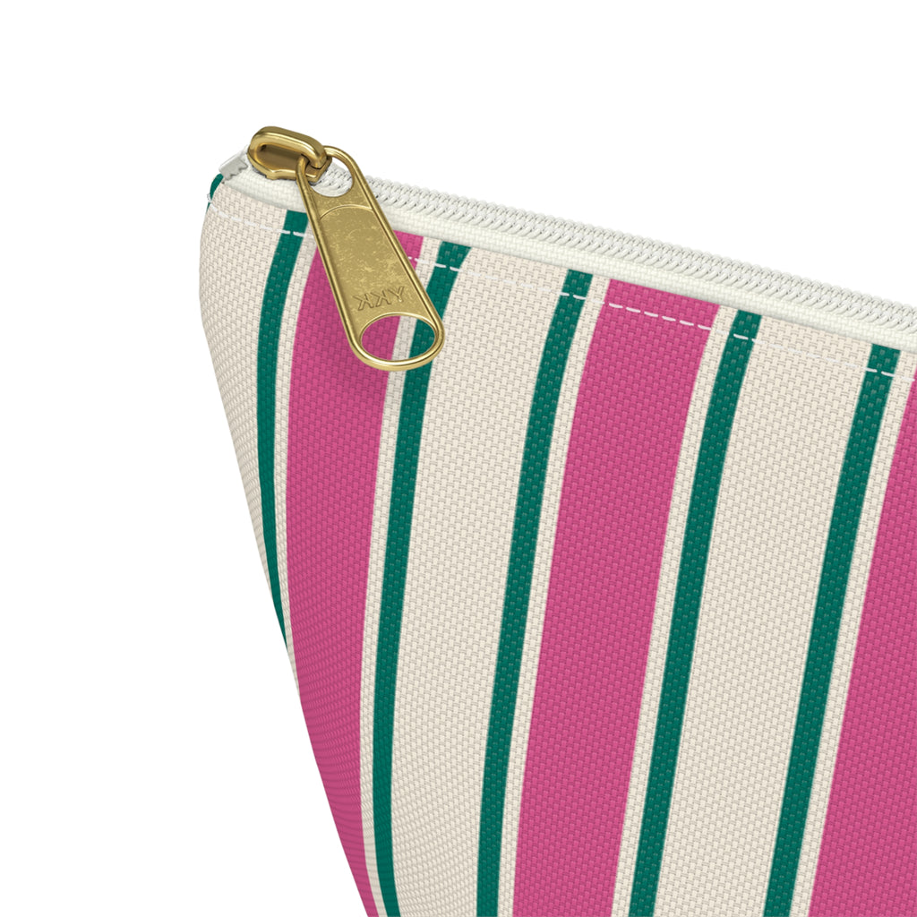 Close-up of the pink, green and cream stripes and gold zipper pull on the makeup bag