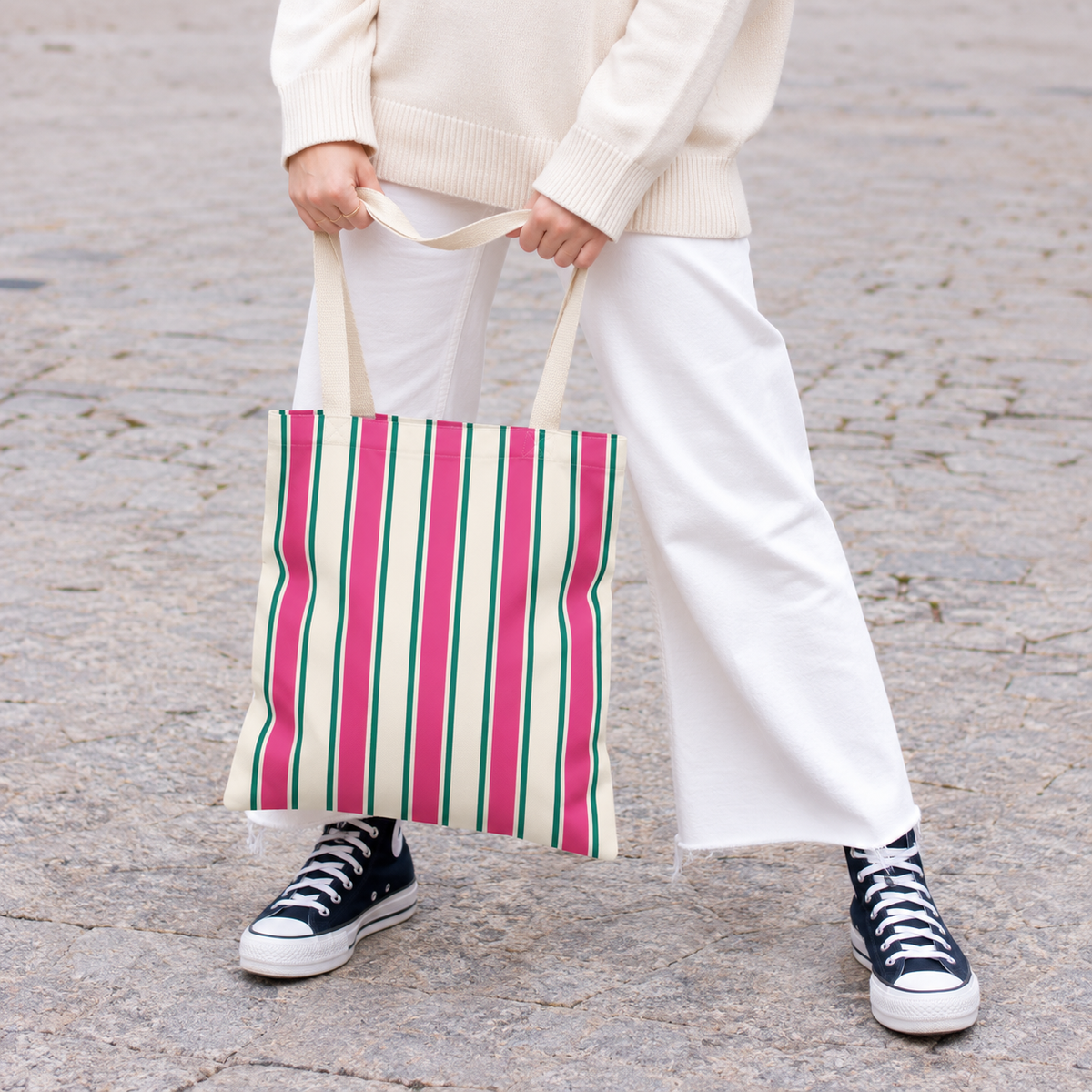 Model in white trousers carrying the Pink Green Cream Striped tote bag