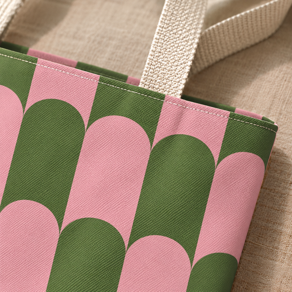 Close-up of the pink and green scallop print and beige handle on the tote bag