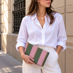 Woman holding the pink green striped makeup bag in a white shirt