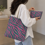 Woman carrying the zebra print tote bag next to the matching makeup bag