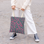 Woman in white trousers and sneakers holding the zebra print tote bag