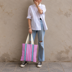 Full-length model photo with the Pink Leopard Striped tote bag against a wall