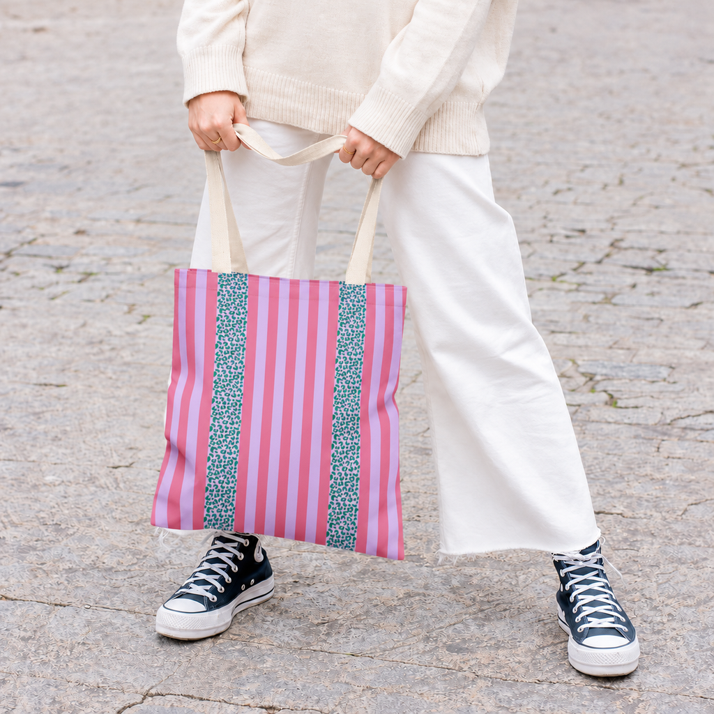 Model in white trousers carrying the Pink Leopard Striped tote bag