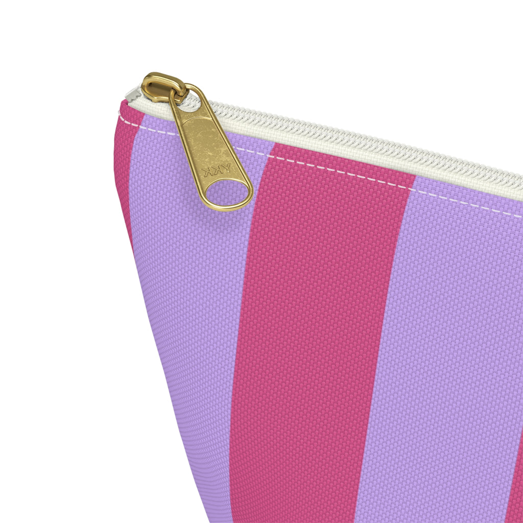 Close-up of the hot pink and lilac stripes and gold zipper pull on the makeup bag