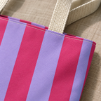 Close-up of the hot pink and lilac stripes and the handle of the striped tote bag