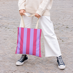 Model in white trousers carrying the Pink Lilac Striped tote bag