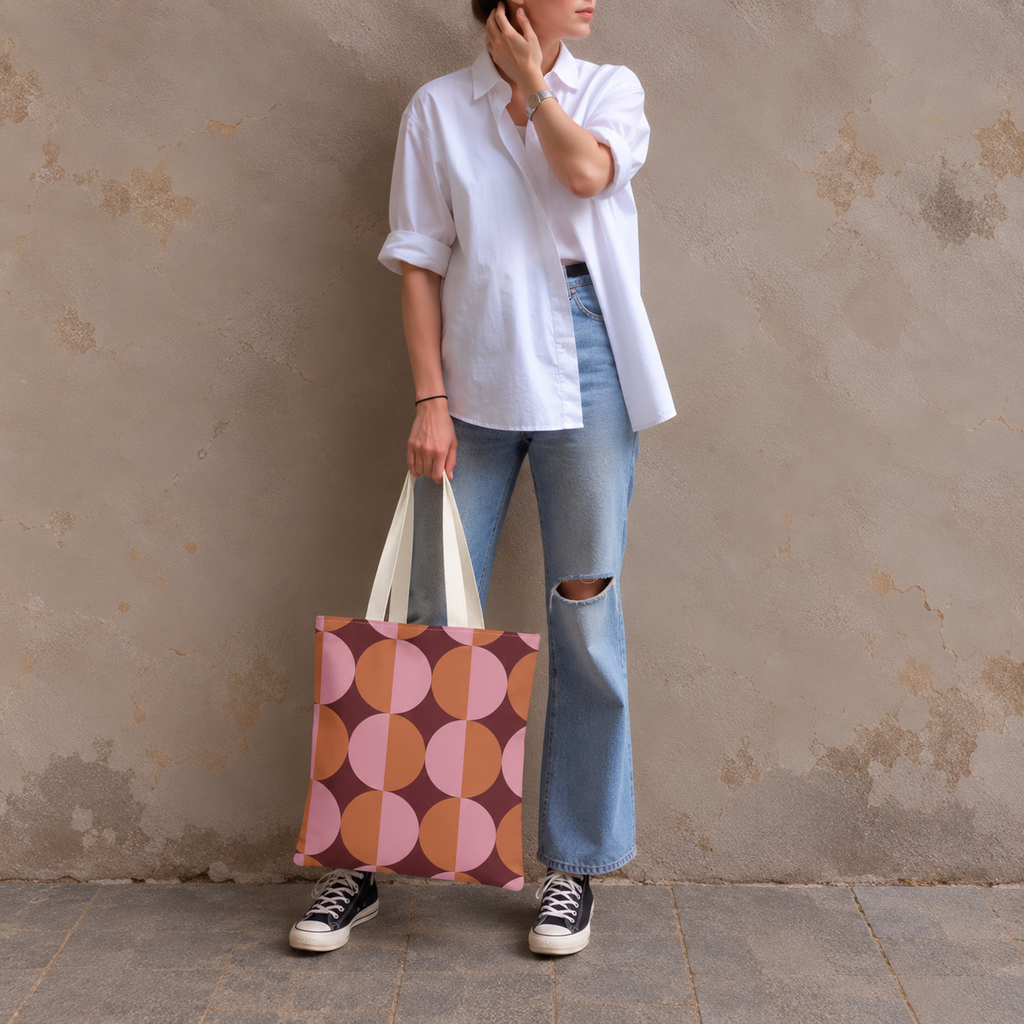 Woman in white shirt and jeans carrying the pink orange geometric tote bag