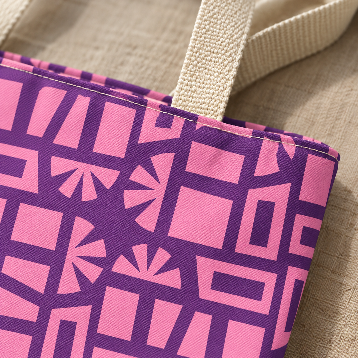 Close-up of the pink and purple geometric print and cream handle on the tote bag
