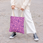 Model holding the Pink Purple Geometric Print tote bag in front of white trousers