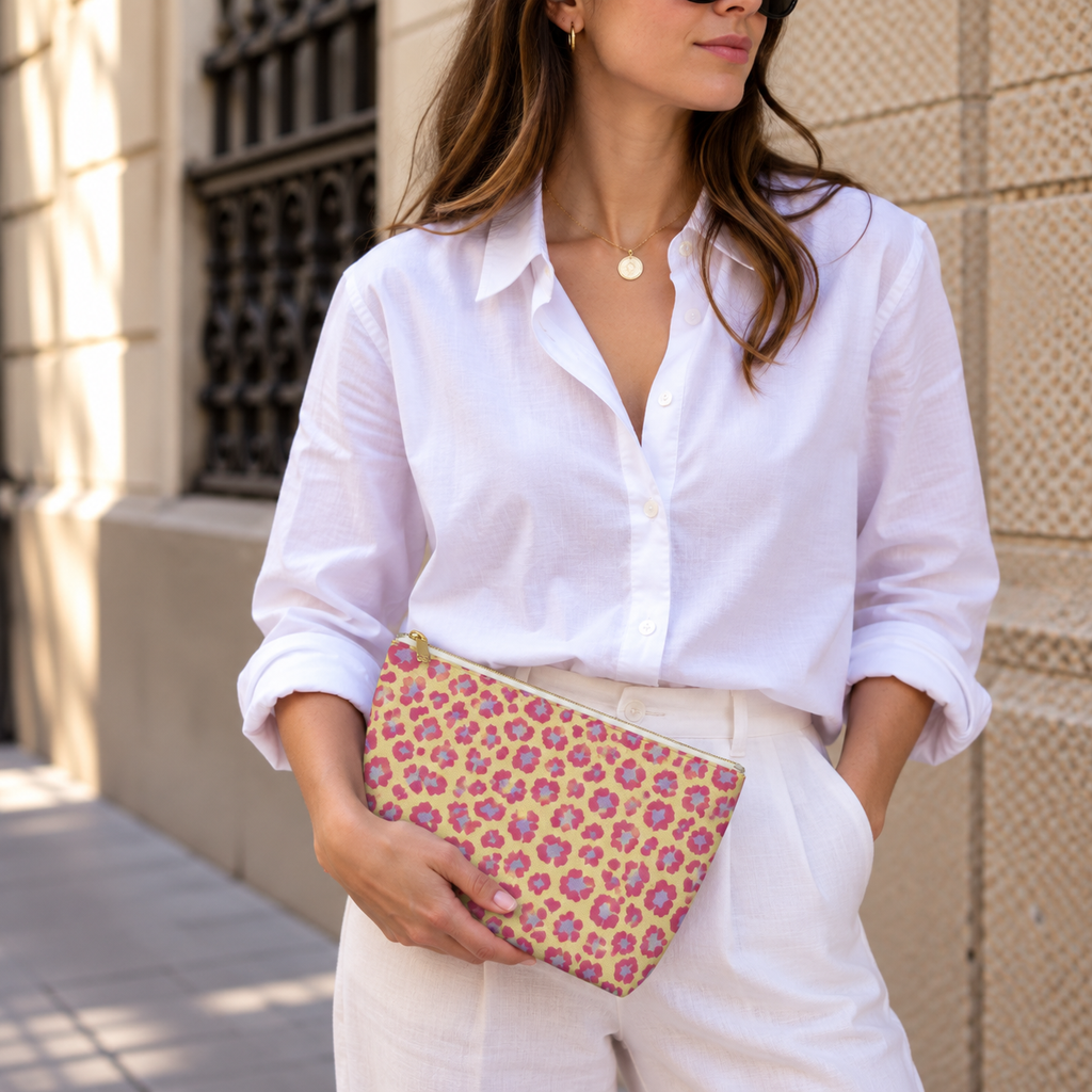 Woman in white shirt holding the pink purple leopard print makeup bag as a clutch