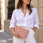Woman in white shirt holding the pink purple leopard print makeup bag as a clutch