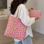 Pink purple leopard print tote bag on the shoulder with a matching makeup bag in hand