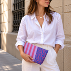 Woman in a white shirt holding the zebra stripe makeup bag as a clutch