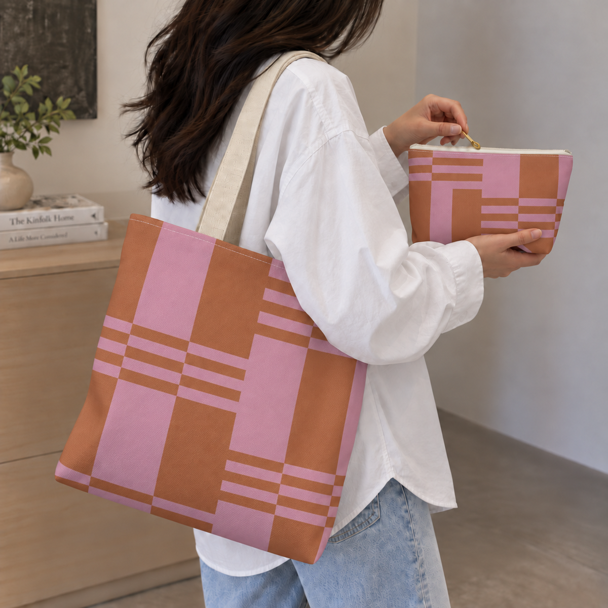 Woman in a white shirt carrying the pink terracotta color block tote bag with the matching makeup bag