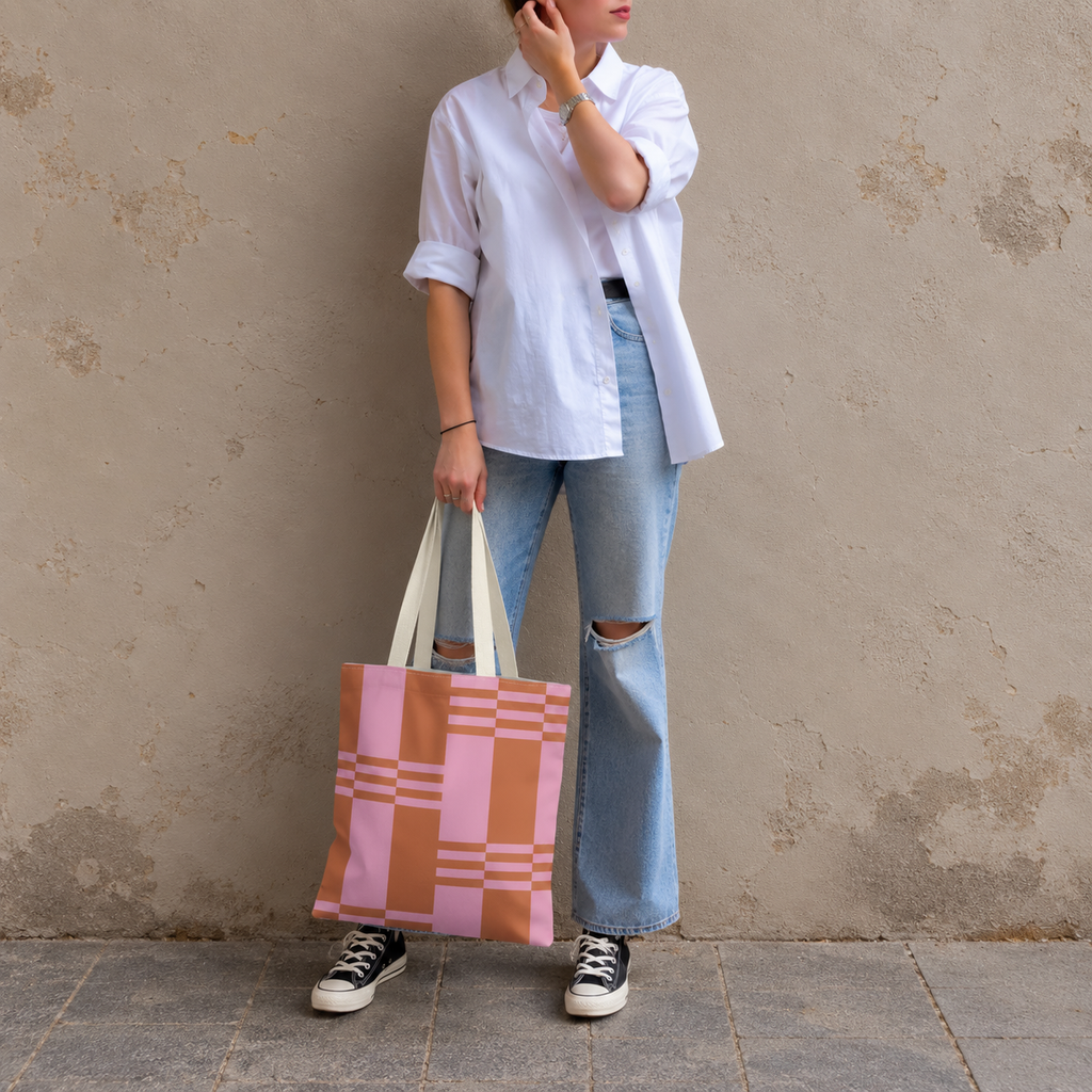 Model in jeans and a white shirt standing with the pink terracotta color block tote bag