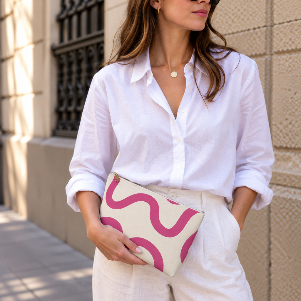 Woman in a white shirt holding the pink wavy line makeup bag as a clutch