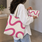 Woman carrying the matching tote bag and holding the pink wavy line makeup bag