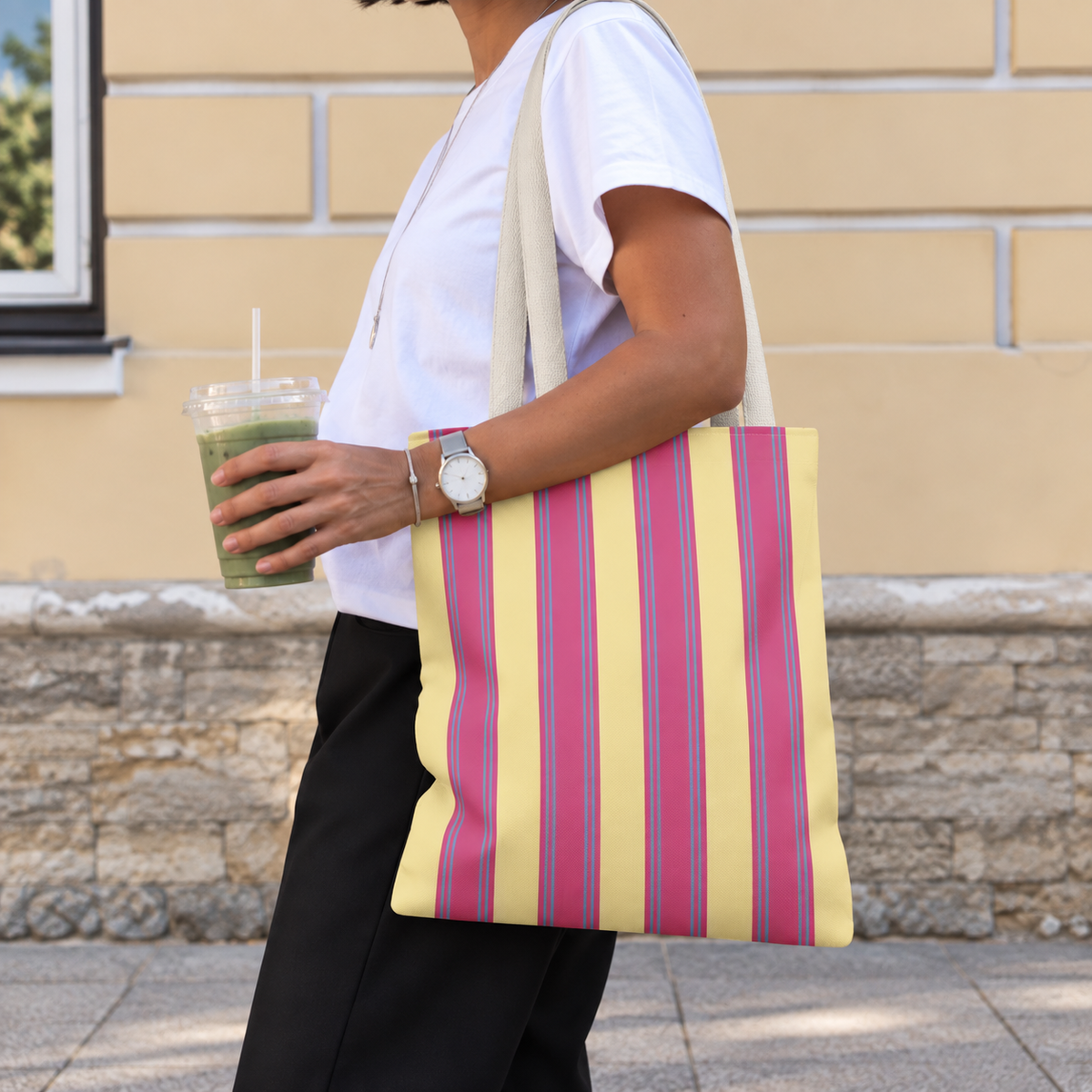 Woman walking with the Pink Yellow Striped tote bag on her shoulder