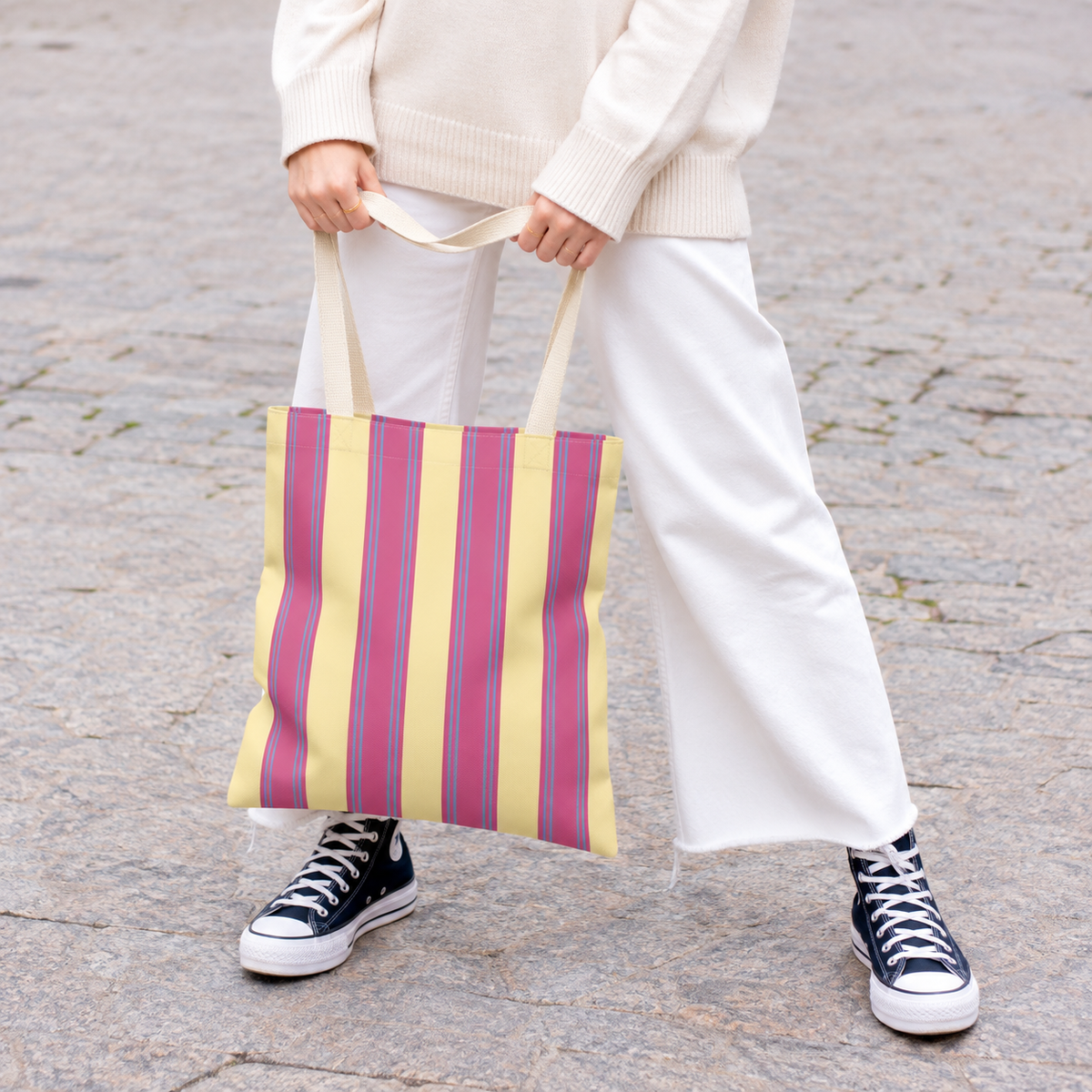 Model in white trousers carrying the Pink Yellow Striped tote bag