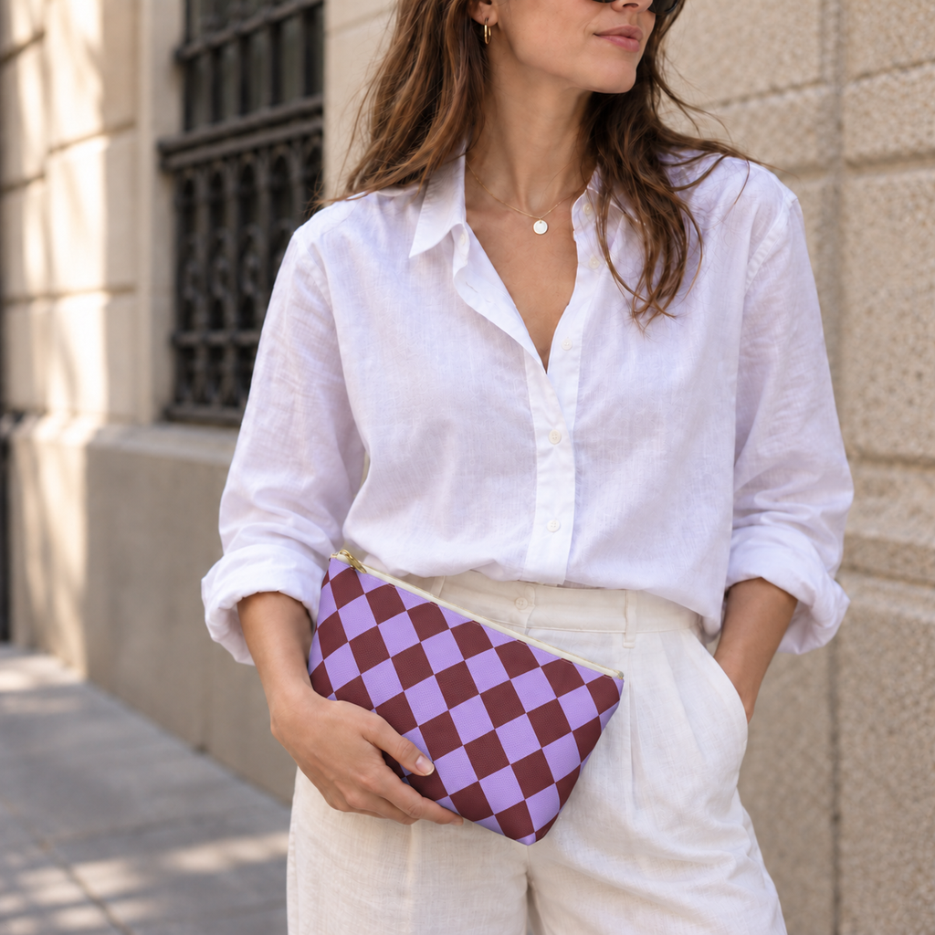 Woman in white shirt holding the purple burgundy checkered makeup bag as a clutch