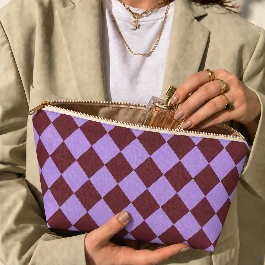 Hands holding the purple burgundy checkered makeup bag with a perfume bottle inside
