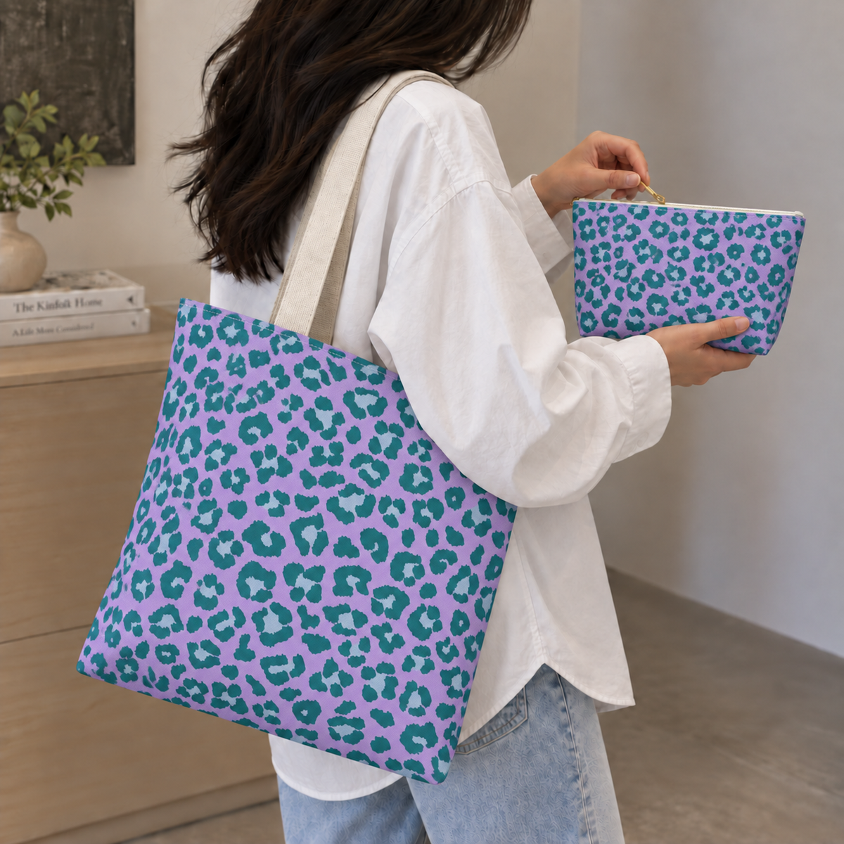 Purple green leopard print tote bag on the shoulder with a matching makeup bag in hand