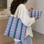 Woman carrying the purple striped tote bag next to the matching makeup bag