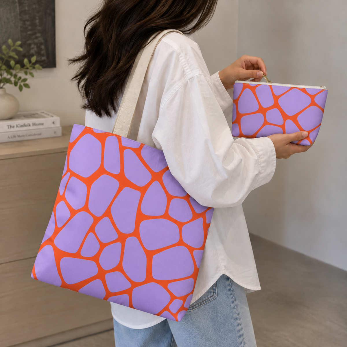 Woman with a giraffe print tote bag and matching purple orange makeup bag in hand