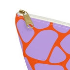 Close-up of the gold zipper pull and lilac and orange giraffe pattern on the makeup bag