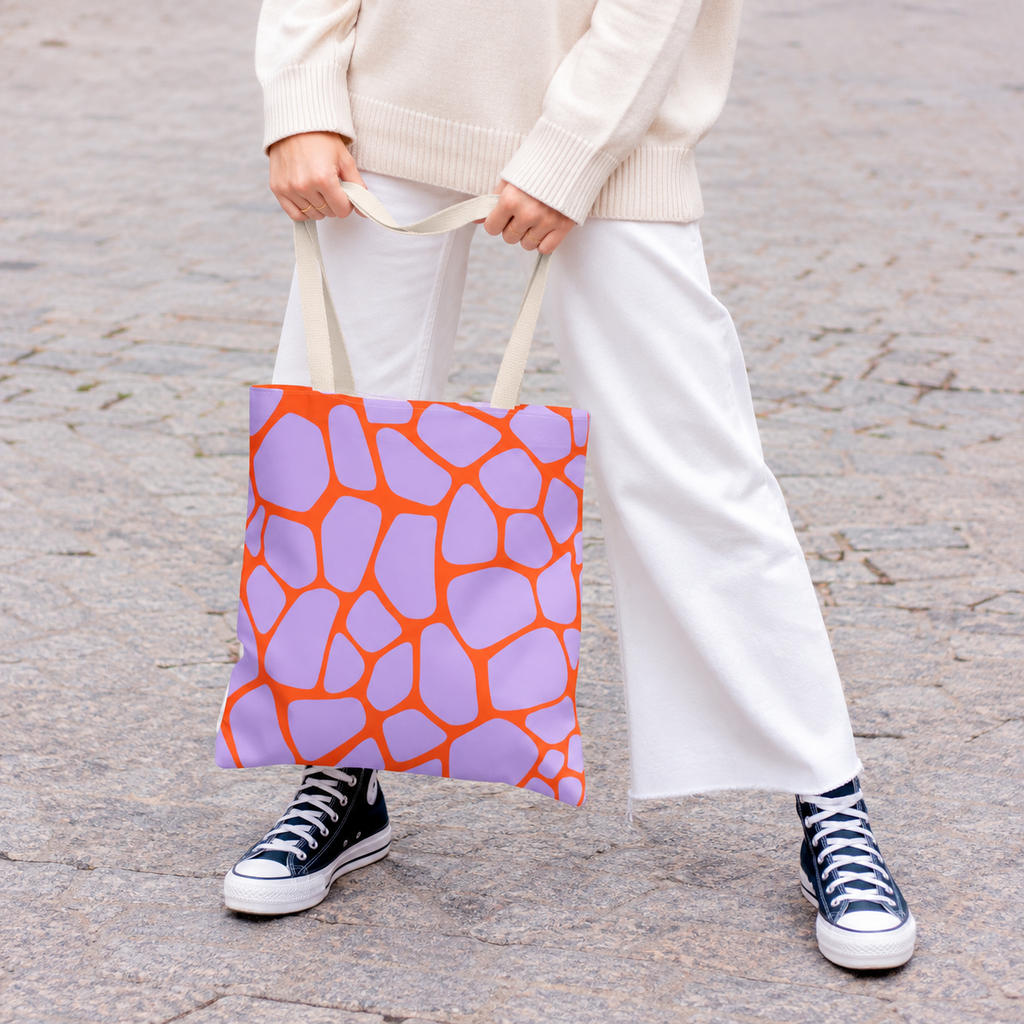 Woman in white trousers carrying the purple orange giraffe print tote bag