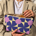 Woman holding the purple pink geometric makeup bag open with the gold zipper